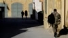 A Greek Cypriot soldier, right, walks toward a military guard post across the U.N. buffer zone that divides the Greek Cypriot- and Turkish Cypriot-controlled areas, in the divided capital Nicosia, Cyprus, Jan. 12, 2017. 