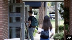 In this Wednesday, Oct. 31, 2018 photo, students enter a polling place to cast their ballots during a Vote for Our Lives event at the University of Central Florida in Orlando, Fla.