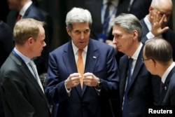 From left, British Ambassador to the U.N. Matthew Rycroft, U.S. Secretary of State John Kerry, Britain's Foreign Secretary Philip Hammond, U.N. Secretary General Ban Ki-moon speak before a meeting of the U.N. Security Council in New York, Dec. 18, 2015.
