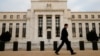 FILE - A man walks past the Federal Reserve building in Washington, D.C., Dec. 16, 2015.