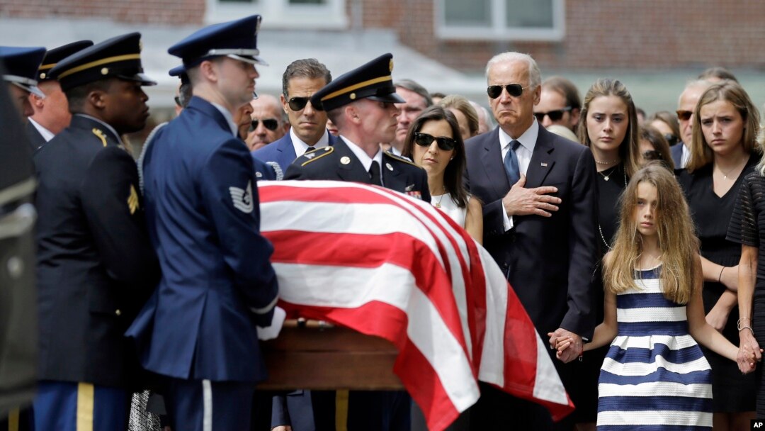 FILE - Vice President Joe Biden, accompanied by his family, watches an honor guard carry a casket containing the remains of his son Beau Biden into a funeral service at St. Anthony of Padua Roman Catholic Church in Wilmington, Del., June 6, 2015. 