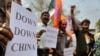 FILE - Indian activists shout slogans and hold placards during a protest in Guahati, India, in 2012. 