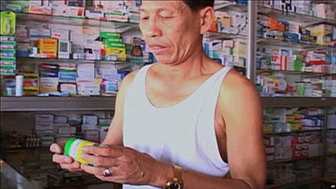 Cambodian man purchases malaria medicine at local pharmacy