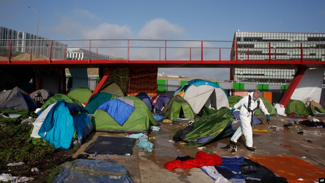 A Paris town hall worker clears a migrant makeshift camp, in Paris, May 30, 2018. 
