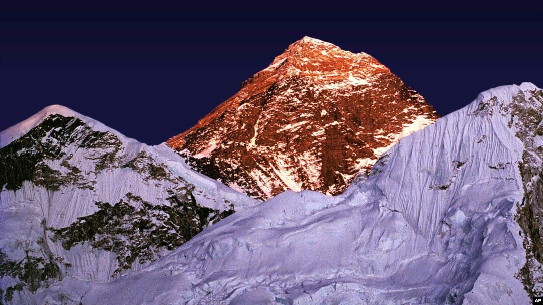 FILE - A golden glow is cast as the sun sets on the worlds highest mountain, center, seen from Kalapathar, on the trail to Everest, Nepal, Tuesday Nov. 15, 1983. (AP Photo/Bikas Das)