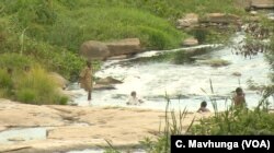 Children bath and swim in a river as people turn to unprotected sources of water in Harare, Zimbabwe, March 7, 2019.