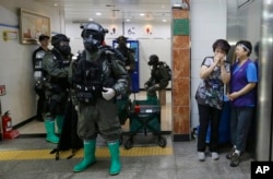 South Korean army soldiers stand as women watch during an anti-terror drill as part of the Ulchi Freedom Guardian exercise, at Yoido Subway Station in Seoul, South Korea, Aug. 23, 2016.