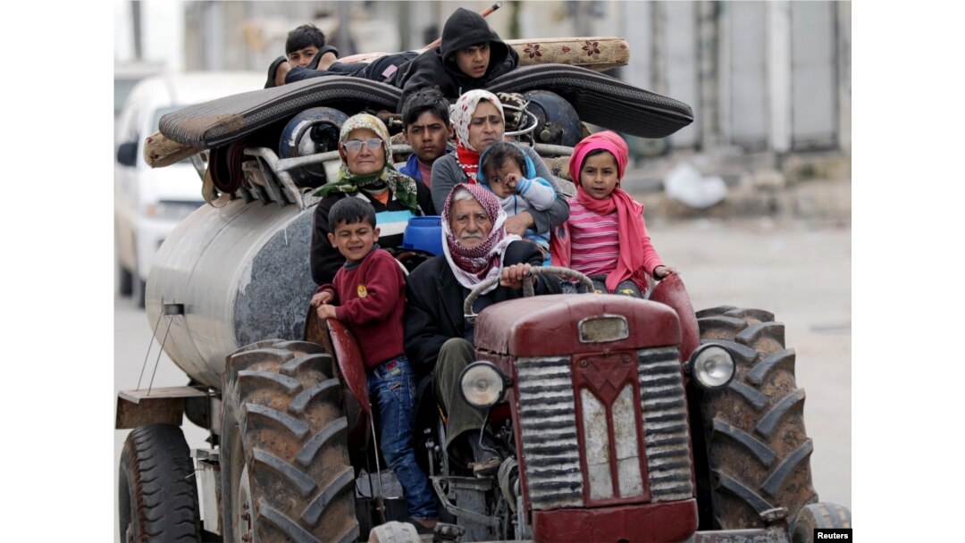 FILE - People flee after Turkish-backed Free Syrian Army fighters captured Khaldieh village in eastern Afrin, Syria, March 10, 2018.