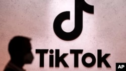ARCHIVO – Un visitante pasa frente a los espacios de exhibición de TikTok en la feria de juegos de computadora de Colonia, Alemania, el jueves 25 de agosto de 2022. (AP Foto/Martin Meissner, Archivo).