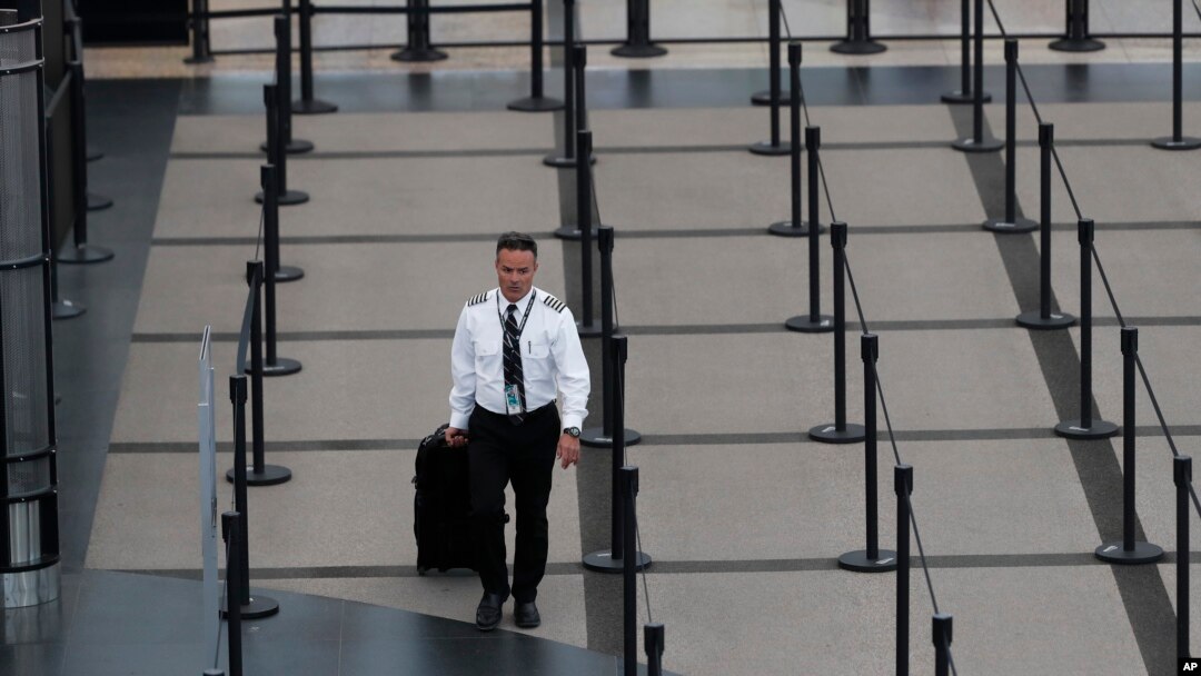 A pilot heads through the empty south security checkpoint as a statewide stay-at-home measure to stem the rapid spread of the new coronavirus remains in place at Denver International Airport, April 9, 2020.