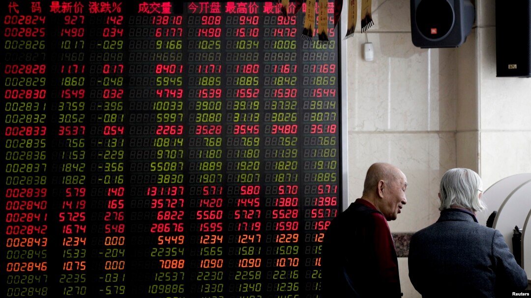 Investors chat near an electronic board displaying stock prices at a brokerage house in Beijing, Jan. 18, 2019. Chinese stocks rose Friday on signs of possible progress in negotiations over Beijing's tariff war with Washington. 