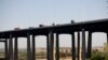 Traffic moves along a bridge as seen from a train in New Jersey, May 18, 2021.