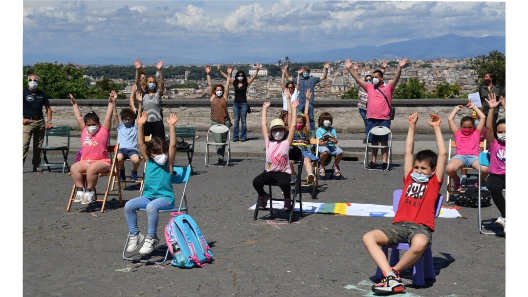 Parents and children take part in a flashmob entitled "Open School" at the Gianicolo Belvedere overlooking Rome on June 8, 2020, to mark the end of their "unusual school year" as the country eases its lockdown.