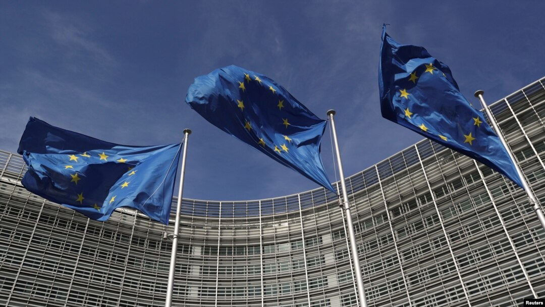 FILE - European Union flags flutter outside the European Commission headquarters in Brussels, Belgium, March 24, 2021. 