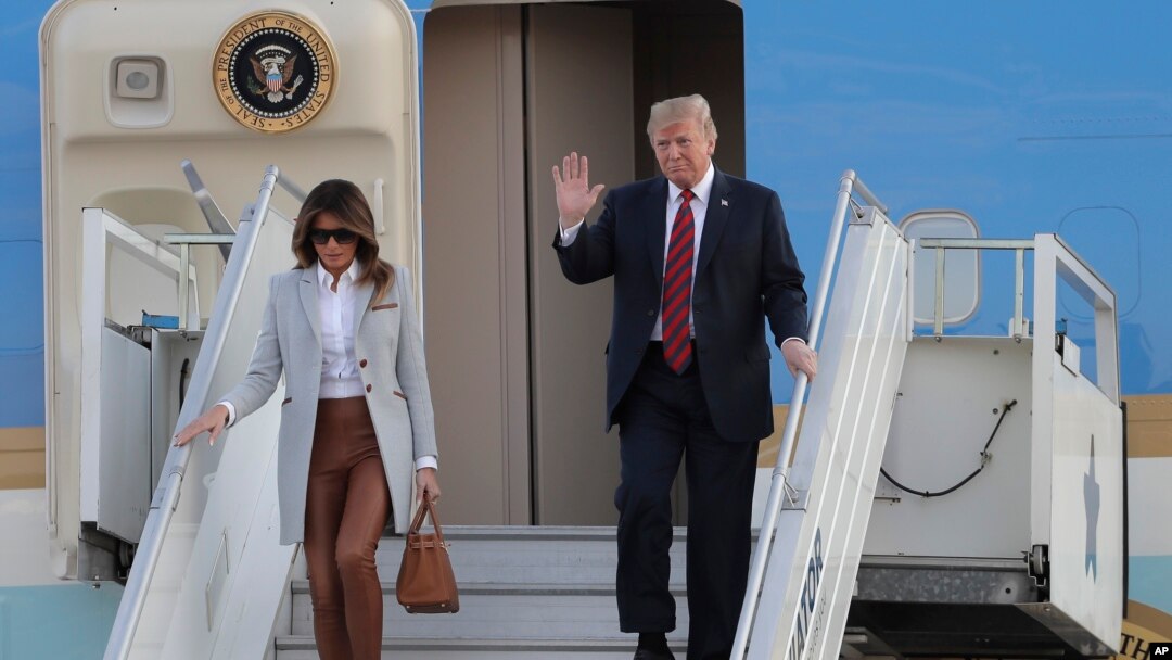 U.S. President Donald Trump, right, waves as he and first lady Melania Trump arrive at the airport in Helsinki, Finland, July 15, 2018, on the eve of his meeting with Russian President Vladimir Putin.
