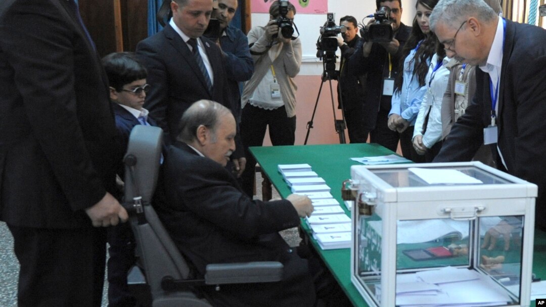 President Abdelaziz Bouteflika, sitting on a wheelchair, prepares to vote in the presidential elections in Algiers, Thursday, April 17, 2014.