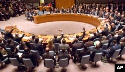 A gathering in the U.N. Security Council of foreign ministers lead by U.S. Secretary of State John Kerry vote on a draft resolution concerning Syria, at U.N. headquarters, Dec. 18, 2015.