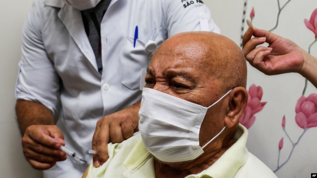 Jose Pereira Lima gets his shot of the COVID-19 vaccine produced by China's Sinovac Biotech Ltd., during the start of the vaccination in elderly people who live in public shelters, in Sao Paulo, Brazil, Jan. 19, 2021. 