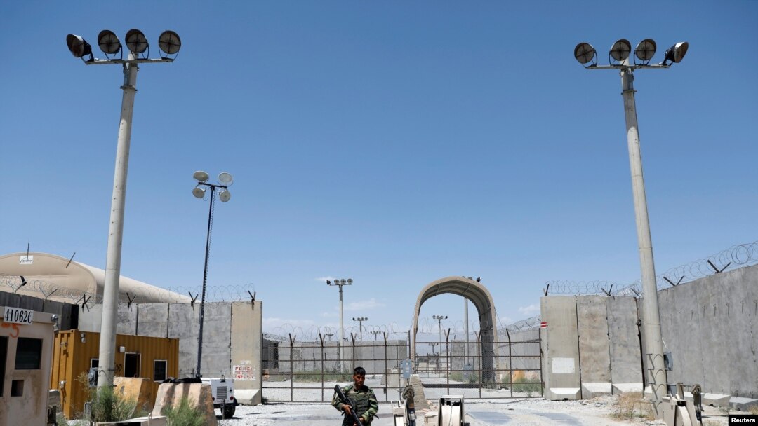 FILE - An Afghan National Army soldier stands guard at the gate of Bagram U.S. air base, on the day the last of American troops vacated it, Parwan province, Afghanistan, July 2, 2021. 