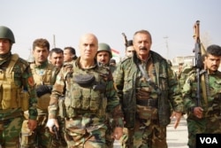 Senior Kurdish peshmerga and their soldiers start moving briskly toward the sound of gunfire in Bashiqa, Iraq, Nov. 8, 2016. (J. Dettmer/VOA)