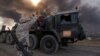 Iraqi soldiers are seen in Qayyara, Iraq, Oct. 22, 2016. The fumes in the background are from oil wells that were set ablaze by Islamic State militants.