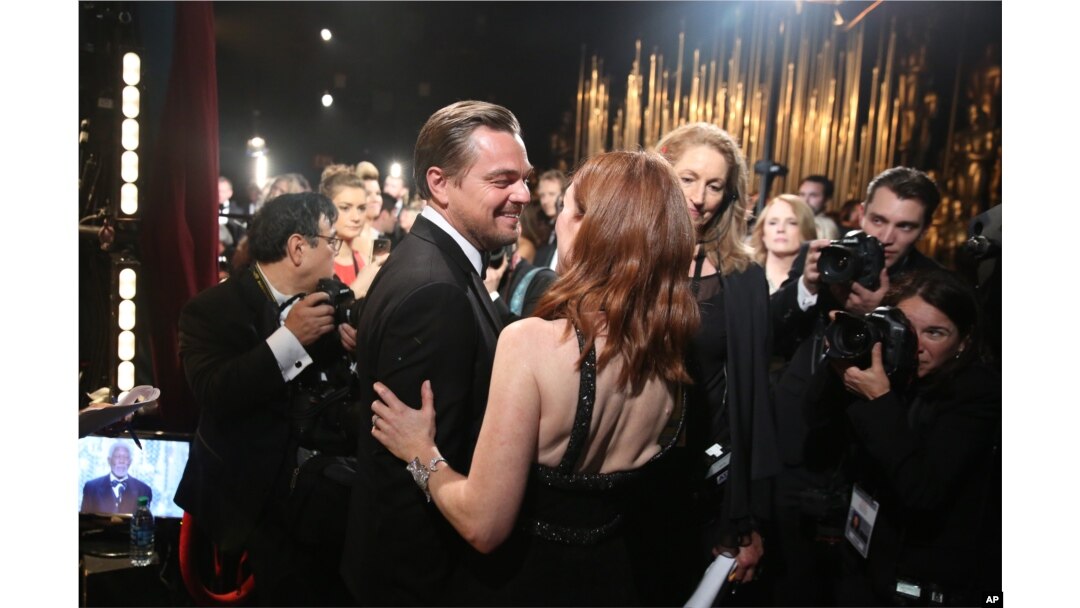 Leonardo DiCaprio, winner of the award for best actor in a leading role for “The Revenant” (l) and Julianne Moore appear backstage at the Oscars, Feb. 28, 2016, at the Dolby Theatre in Los Angeles.