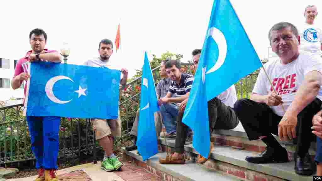 Uyg'urlar Sharqiy Turkiston bayroqlarini ko'tarib, Xitoy elchixonasi qarshisida bu davlatning uyg'urlarga qarshi siyosatini qoralab, namoyish qilmoqda, Vashington, 3-avgust, 2014-yil. Odil Ruzaliev surati