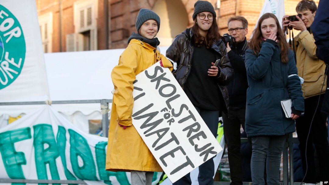 Swedish environmental activist Greta Thunberg holds a sign with writing reading in Swedish "School strike for the climate" as she attends a climate march, in Turin, Italy, Dec. 13, 2019. 