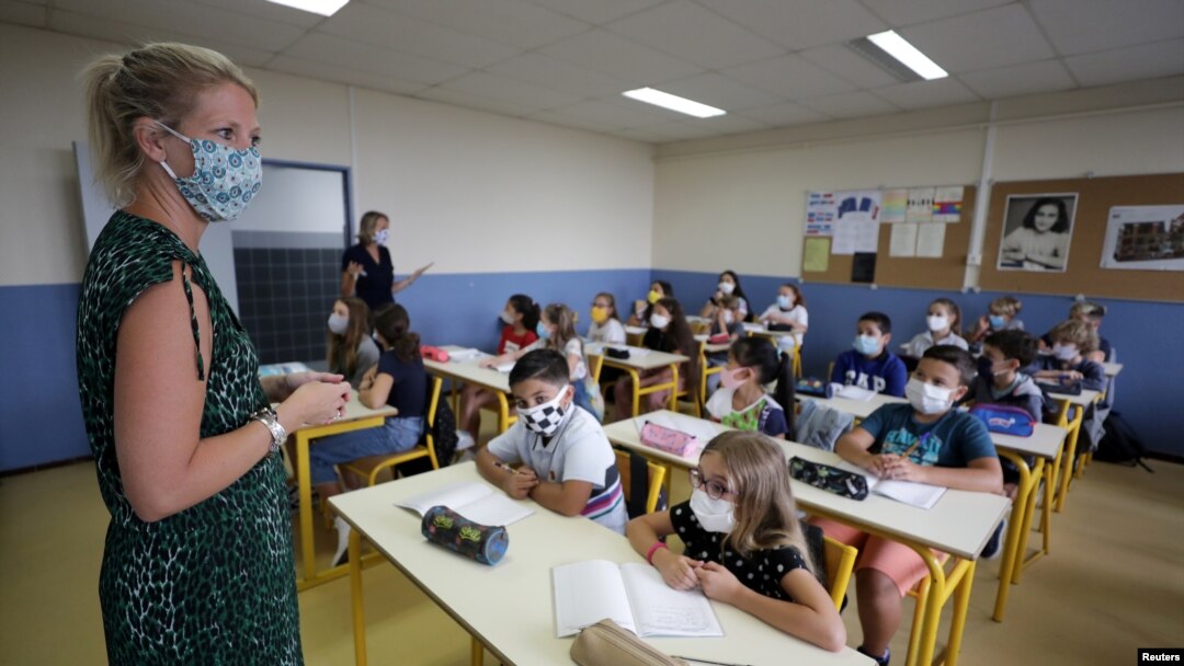 A teacher, wearing a protective face mask, teaches students in a classroom at the College Henri Matisse school in Nice, France, Sept. 1, 2020.