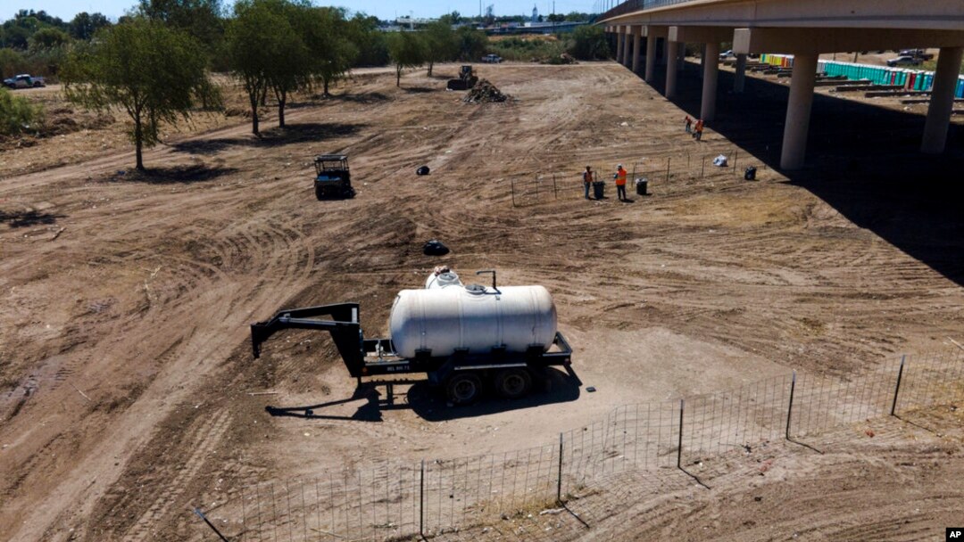 Crews clear an area that had been used by migrants, many from Haiti, as an encampment along the Del Rio International Bridge, Sept. 24, 2021, in Del Rio, Texas.