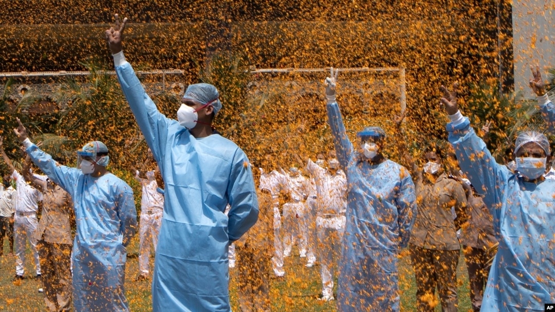An Indian Air Force helicopter showers flower petals on the staff of INS Asvini hospital in Mumbai, India, May 3, 2020.