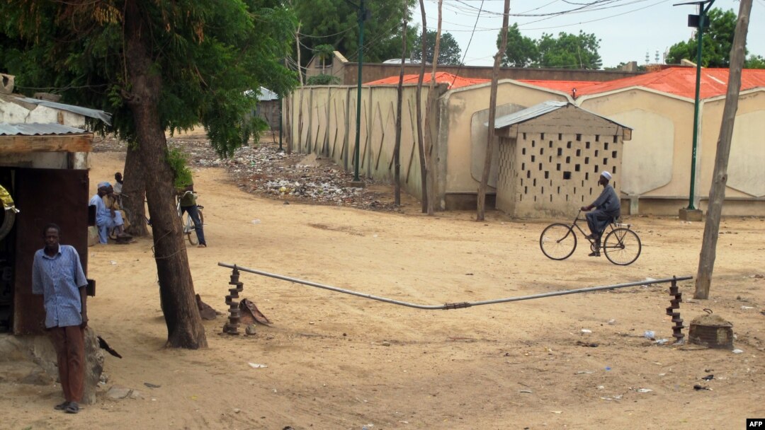 FILE - A man rides a bicyle in the town of Amchide, northern Cameroon, on the border with Nigeria, June 17, 2014. 