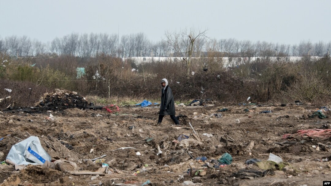 FILE - A man walks among remains of taken down shelters during the dismantling of the southern part of the so-called "Jungle" migrant camp in Calais, northern France, March 10, 2016.