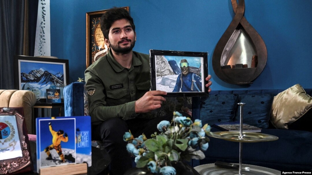 FILE - This picture taken Nov. 16, 2021, shows Pakistani mountaineer Shehroze Kashif holding a painting of himself during an interview with AFP at his home in Lahore.