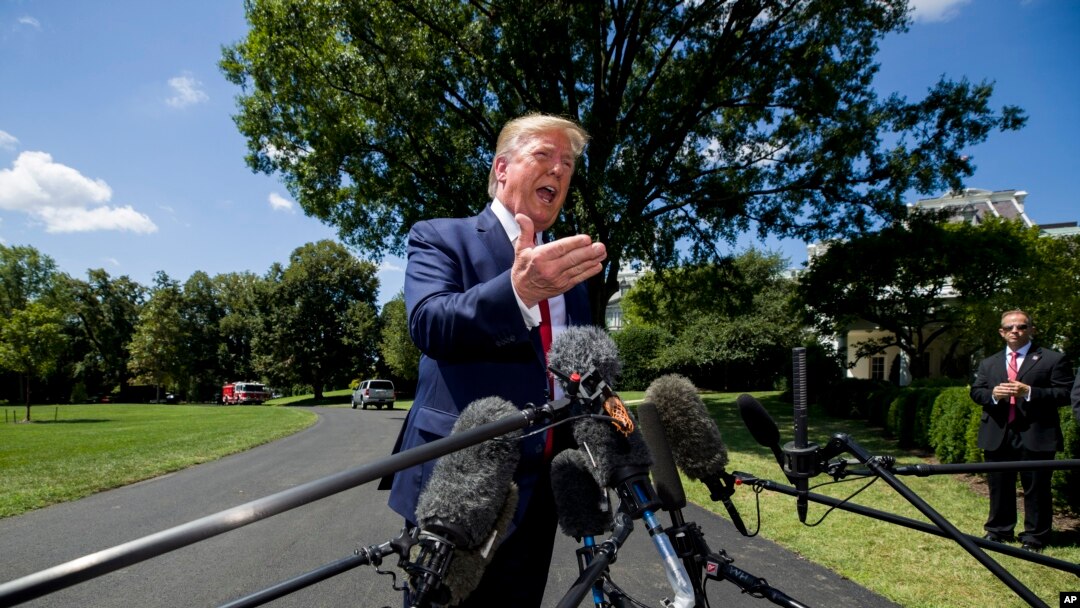 President Donald Trump speaks with reporters before departing on Marine One on the South Lawn of the White House, Aug. 21, 2019, in Washington. 