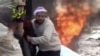 This video provided by Shaam News Network, which has been authenticated, shows a wounded man being pulled from the site of a Syrian government airstrike on a gas station in the eastern Damascus suburb of Mleiha, Syria, Jan. 2, 2013. 