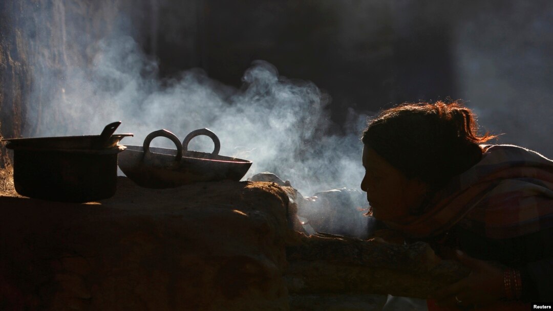 A woman uses firewood to cook food in her home, in Sapay, Nepal, about 900 kilometers from Kathmandu, Feb. 17, 2014.