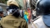 FILE - A Muslim woman (C) shouts at security personnel that patrol on the streets in Shaheen Bagh area after removing demonstrators continuously protesting against a new citizenship law, March 24, 2020.