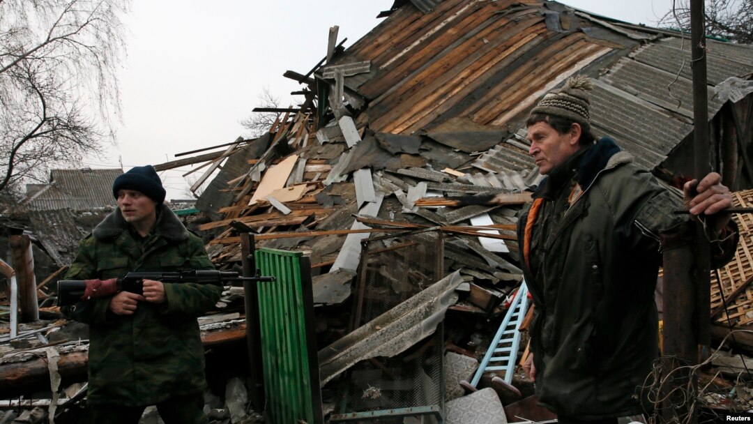 Geopolitical instability, as in eastern Ukraine, could undermine global economic growth, a new U.N. report warns. Here, a pro-Russian rebel and a resident view remnants of a house shelled near Donetsk, Ukraine, Dec. 14, 2014. 