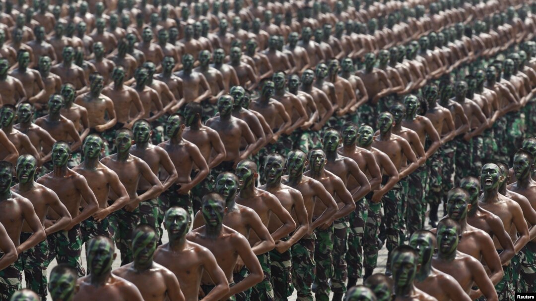 FILE - Indonesian army soldiers shout slogans as they run during a rehearsal for a ceremony marking the 70th anniversary of Indonesia's military in Cilegon, Banten province.