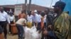 People hand out foodstuff donated by the U.S at the West Point area that has been hard hit by the Ebola virus in Monrovia, Liberia, Aug. 26, 2014.