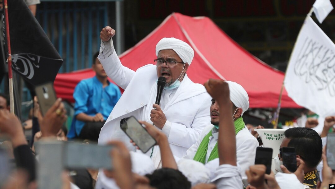 FILE - Hardline Islamic cleric Rizieq Shihab, center, speaks to a group of his followers in Jakarta, Indonesia, Nov. 10, 2020.