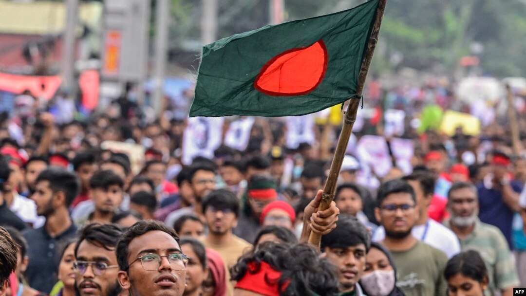 A student carrying the Bangladeshi flag takes part in a march as demonstrators demand justice for victims arrested and killed in the recent nationwide protests against job quotas, in Dhaka on Aug. 3, 2024.