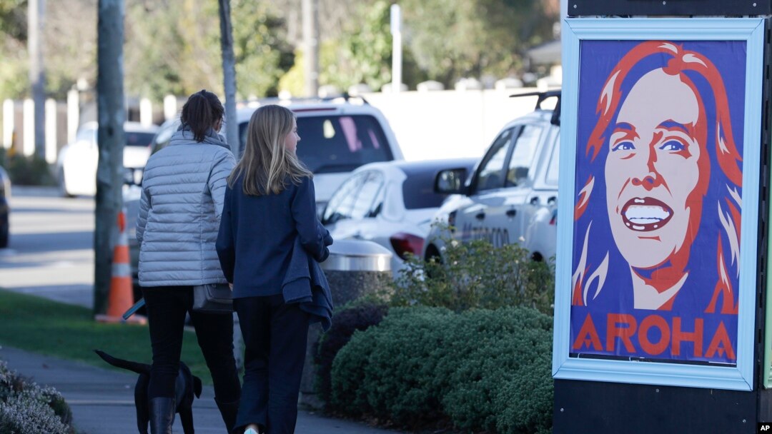 Pedestrians walk past a billboard featuring Prime Minister Jacinda Ardern with the word Aroha, meaning love, in Christchurch, New Zealand, June 8, 2020. 