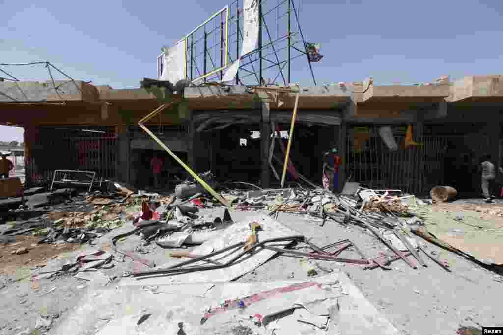 People inspect the site of a car bomb attack in the Ur district, northeastern Baghdad, Sept. 30, 2013.