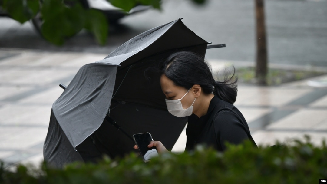A woman holding her umbrella walks in strong winds in Seoul, South Korea, on Aug. 27, 2020, after Typhoon Bavi hit the Korean Peninsula. 