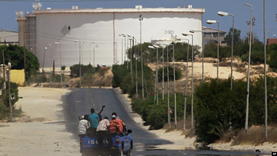 A truck carrying Libyan rebel fighters drives towards the Zawiya oil refinery in Zawiyah, August 17, 2011