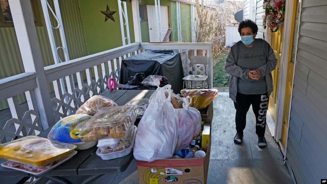 Evelyn Maysonet looks at the food delivery from the Weber-Morgan Health Department, Nov. 24, 2020, in Ogden, Utah. Maysonet has been isolating with her husband and son in their Ogden home since all three tested positive for COVID-19 over a week ago.