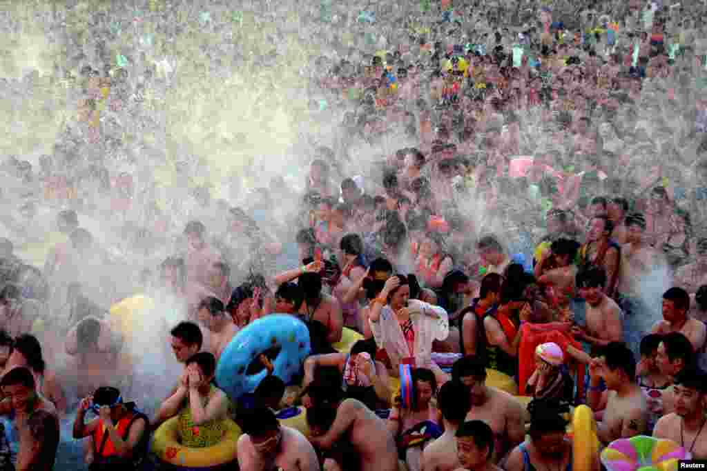 People cool off at a water park on a hot day in Wuhan, Hubei province, China, July 15, 2017.