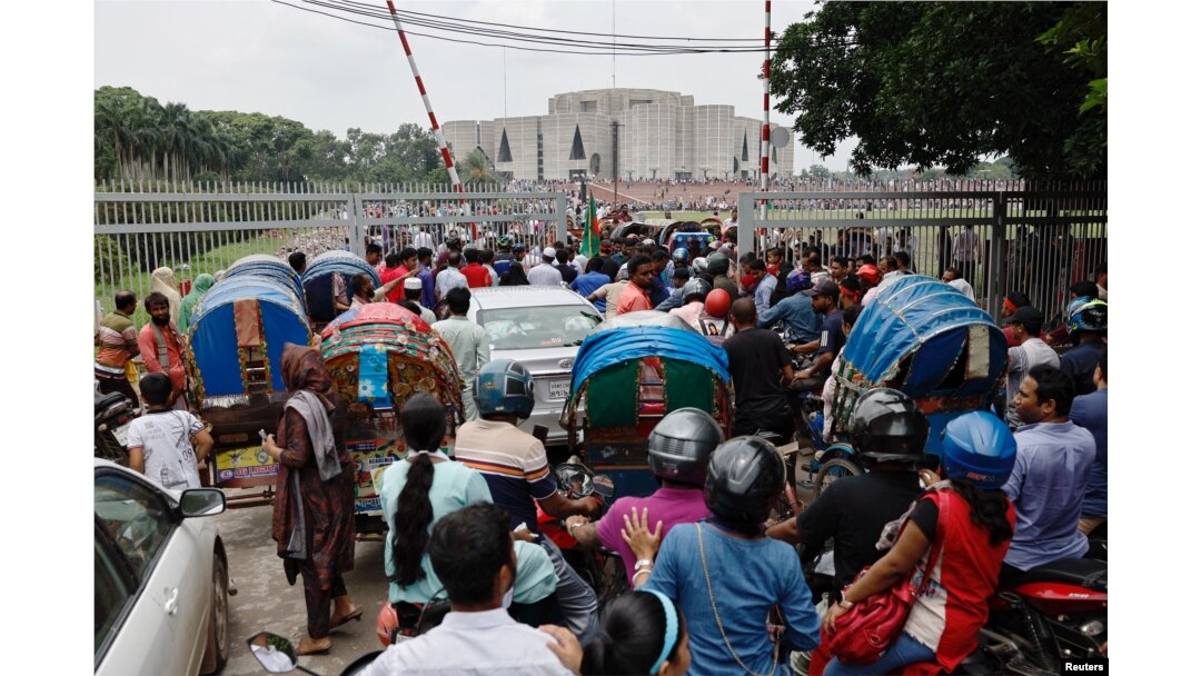 People and vehicles gather outside the Bangladeshi parliament building a day after the resignation of Prime Minister Sheikh Hasina, in Dhaka, Bangladesh, on Aug. 6, 2024.